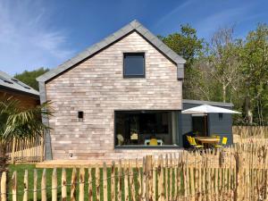 una casa con una recinzione di legno di fronte ad essa di Les cabines du bout du monde - Cabine Duplex , votre maison de vacances de haut standing à Crozon a Crozon