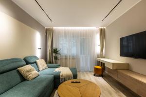 a living room with a blue couch and a television at Downtown Breeze in Constanţa