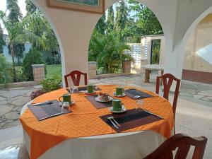 a table with a orange table cloth on top of a patio at Kamsons villa accommodation in Mombasa