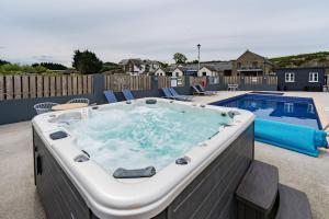 a hot tub on a patio next to a pool at The Barn in Aberystwyth