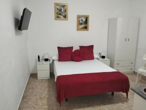 a bedroom with a bed with red pillows at El Rinconcito de Ensueño in Gran Tarajal