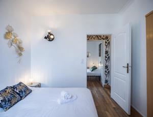 Un dormitorio con una cama blanca y un pasillo. en Le Logis de l'Arc - Chambre 3 - 5min Hypercentre, en Troyes