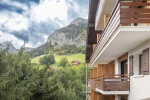 a view from the balcony of a house with a mountain view at Appartement spacieux 6 personnes in Le Grand-Bornand