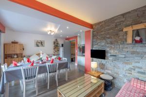 a dining room with a table and a stone wall at Appartement spacieux 6 personnes in Le Grand-Bornand