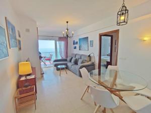 salon ze szklanym stołem i kanapą w obiekcie Carabeo Vista Mar w mieście Nerja