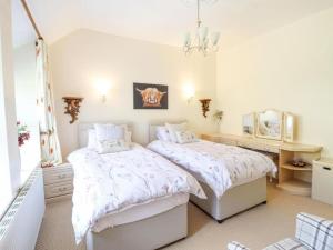 a bedroom with two beds and a mirror at Bryn Glasfor in Barmouth