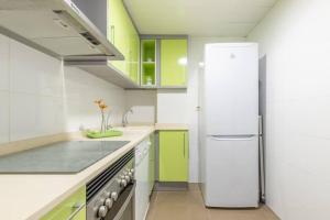 eine Küche mit grünen und weißen Schränken und einem Kühlschrank in der Unterkunft Borumbot,2hab, Wifi ,Vistas Peñón ,Excursiones in Calpe