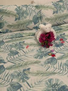 un orsacchiotto con fiori su un letto di Caribbean Dream Vacation Property CD1 a Gros Islet Altre 37 foto