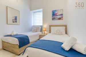 A bed or beds in a room at Stylish 3BR home with large terrace in Mosta by 360 Estates