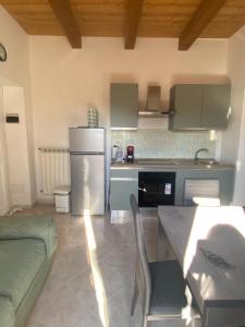 a kitchen with a refrigerator and a table with chairs at Casa campo della fiera in San Lorenzo Nuovo