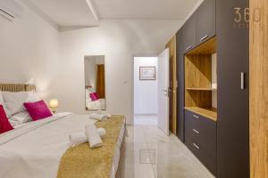 A bed or beds in a room at Stylish 3BR home with large terrace in Mosta by 360 Estates