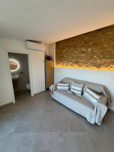 a bedroom with a couch with pillows on it at Dúplex amb vistes al mar 150 mts to Nautical Club Christmas R in Palamós
