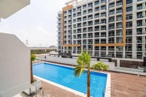 an apartment with a swimming pool and a building at GuestReady - Modern elegance in Dubai in Dubai