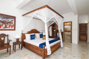 a bedroom with a bed with a canopy at Karibu Beach Resort - Adults Only in Pongwe +87 photos