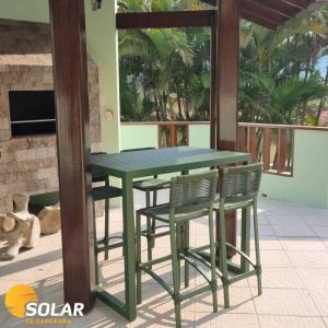 a green table and chairs on a patio at Solar de Garopaba in Garopaba +37 photos