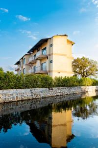 a building next to a river with its reflection in the water at Sigelege Beach Resort in Senga