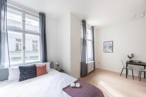 プラハにあるVibrant Old Town Studioの白いベッドルーム(大きな窓、ベッド付)