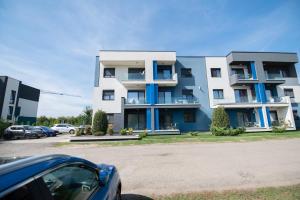 a building with a car parked in a parking lot at Modern Chic Apartment - near Iulius Mall in Timişoara