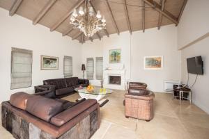a living room with leather furniture and a chandelier at Villa Pomegranate Tree in Katelios