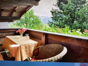 a table and a chair on a balcony with a view at Appartement Foidl mit Kaiser & Hornblick in Oberndorf in Tirol