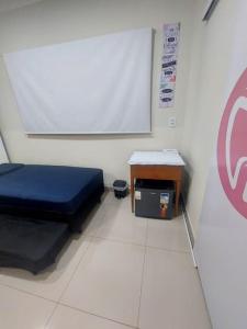 a room with a chalkboard and a blue bed and a table at Aconchego perfeito em São Pedro SP in São Pedro