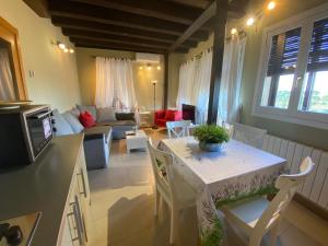 a kitchen and living room with a table and a couch at Apartamentos Refitolería in Segovia