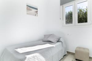 a white bedroom with a bed and a window at Apartamento La esencia del sur A in Vejer de la Frontera +15 photos
