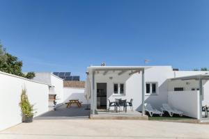 a white house with a patio and a table at Apartamento La esencia del sur A in Vejer de la Frontera