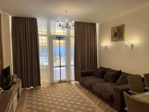 a living room with a couch and a large window at Золотой Бугаз in Gribovka