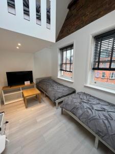 a room with two beds and a table and two windows at Camden BNB in London