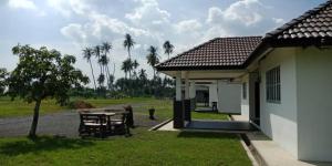 a small house with a table and a patio at Banat Village Stay in Arau +6 photos