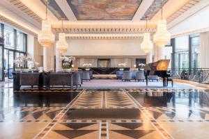 a lobby with a grand piano and a lobby with chandeliers at L'Hôtel du Collectionneur Paris in Paris