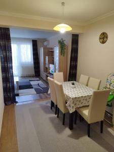 Un comedor con mesa y sillas en Aqua-Vital Prémium Apartmanok, en Hajdúszoboszló