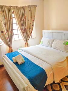 a bedroom with a large white bed with a window at Evergreen Kile homes in Nairobi