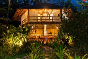 a building with a table and chairs in front of it at Water to Forest Ecolodge in Loboc