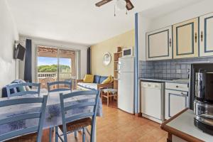 a kitchen and living room with a table and chairs at Appartement Chêne Liège in Sainte-Maxime