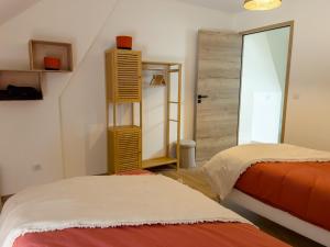 a bedroom with two beds and a closet with a mirror at Logement familial cosy proche d'Auxerre & Chablis in Vergigny
