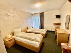 a hotel room with two beds and a television at Pensiunea Casa Saxonia in Râşnov +47 photos