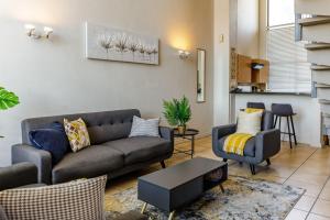 a living room with a couch and two chairs at WeStay Westpoint Apartments in Johannesburg