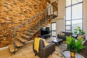 a living room with a brick wall and stairs at WeStay Westpoint Apartments in Johannesburg
