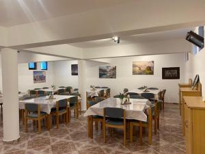a restaurant with tables and chairs in a room at Pensiunea Casa Saxonia in Râşnov