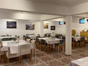 a dining room with white tables and chairs at Pensiunea Casa Saxonia in Râşnov