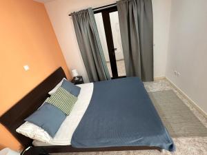 une chambre avec un lit avec des draps bleus et une fenêtre dans l'établissement Coração de Santa Maria, à Santa Maria