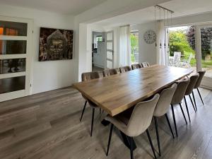 a dining room with a wooden table and chairs at Big Family villa 12p big garden with bathtub and jacuzzi in Zeewolde