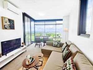 a living room with a couch and a table at Cozy Apt w Park View by Stadiums in Sydney