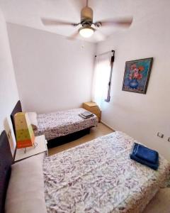 a bedroom with two beds and a ceiling fan at S&H La Consentida in San Juan de los Terreros