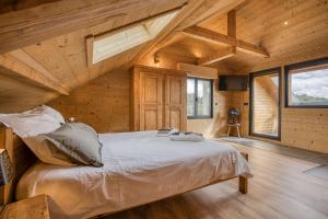 a bedroom with a bed in a wooden house at l'écureuil, chez le charpentier d'antan, la chaleur du bois, le calme de la campagne in Epagny Metz-Tessy