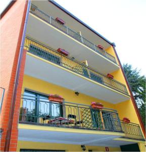un edificio amarillo con balcones y mesas. en B&B Music, en Milán