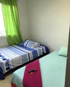 twee bedden in een kamer met een afstandsbediening bovenop bij hotel el oasis de garzon in Garzón