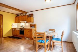 a kitchen with a table and chairs in a room at Haus Albatros Wohnung 3 in Ostseebad Koserow